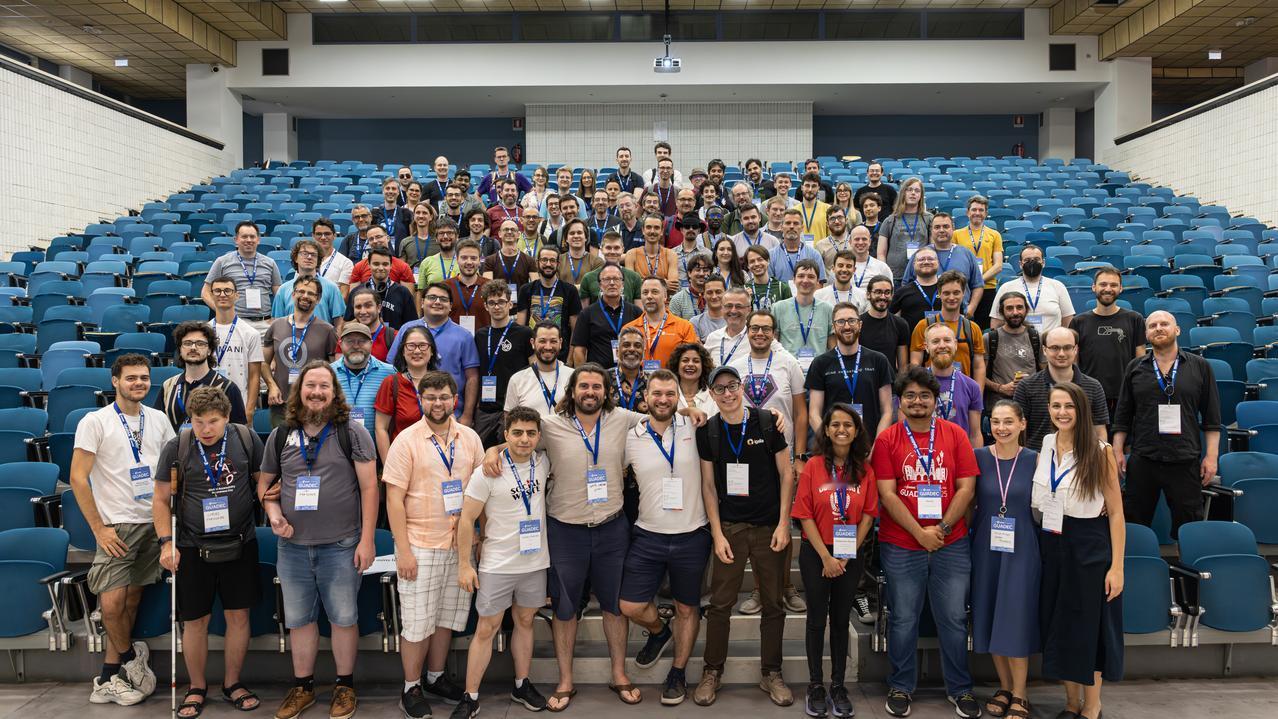 GUADEC 2025 现场，一位盲人开发者站在台阶上，和大家一起合影。

那一