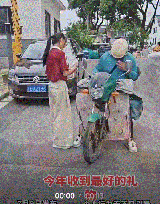 一快递员为女生送来高考录取通知书，而女生下来拿通知书时，为了分享自己这份金榜题名