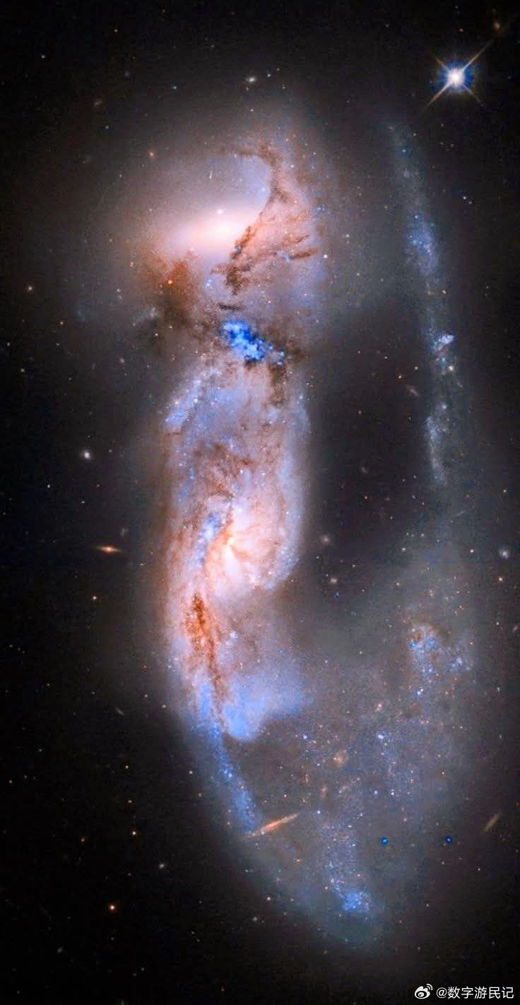 宇宙之舞：当星系拥抱它们的舞伴看似单一、优雅、钩状发光体，实际上是一场慢动作的极