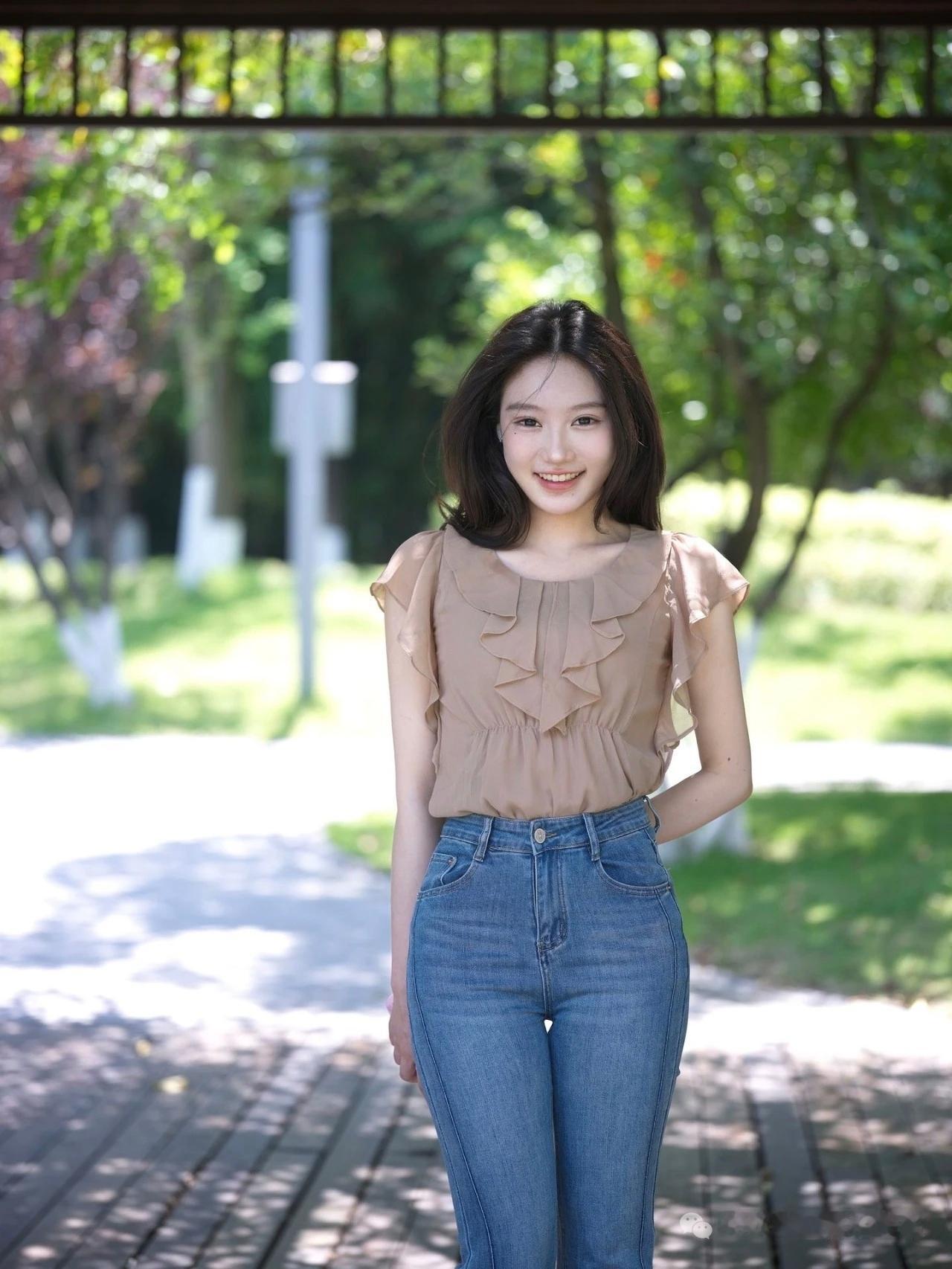 一个女孩在公园里微笑拍照。