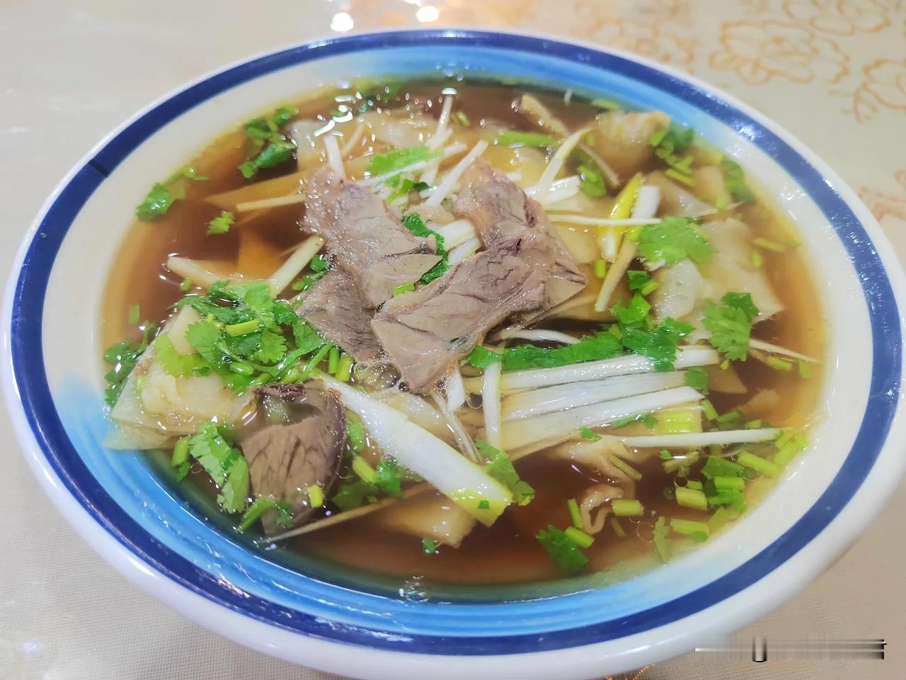 又到这家老店吃了碗标准的牛肉罩饼。说是老店是因为老人还在。这条路美化时，他那暴火