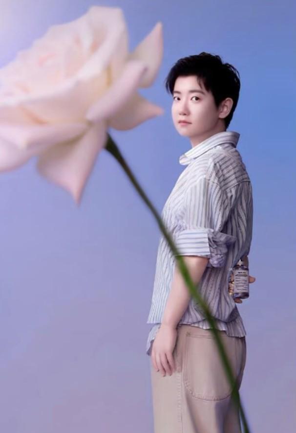 那朵花，我发誓在别处见过。
绸缎材质，渐变粉紫，以同样的角度别在条纹衬衫的第二颗