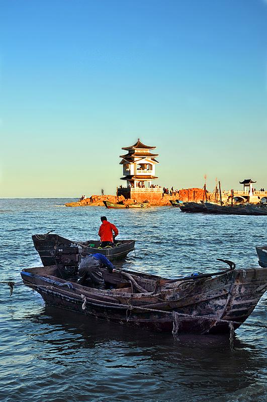 🌅海面上的老渔船在晃悠～红衣大叔弯腰忙活啥呢？远处亭子亮了，像给大海装了盏小灯