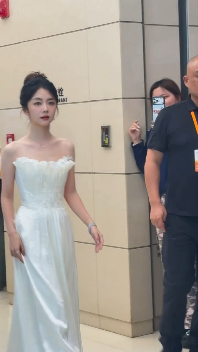 谭松韵抹胸白天鹅 路人镜头下的生图太绝了！谭松韵现身品牌活动，一身抹胸白裙优雅大