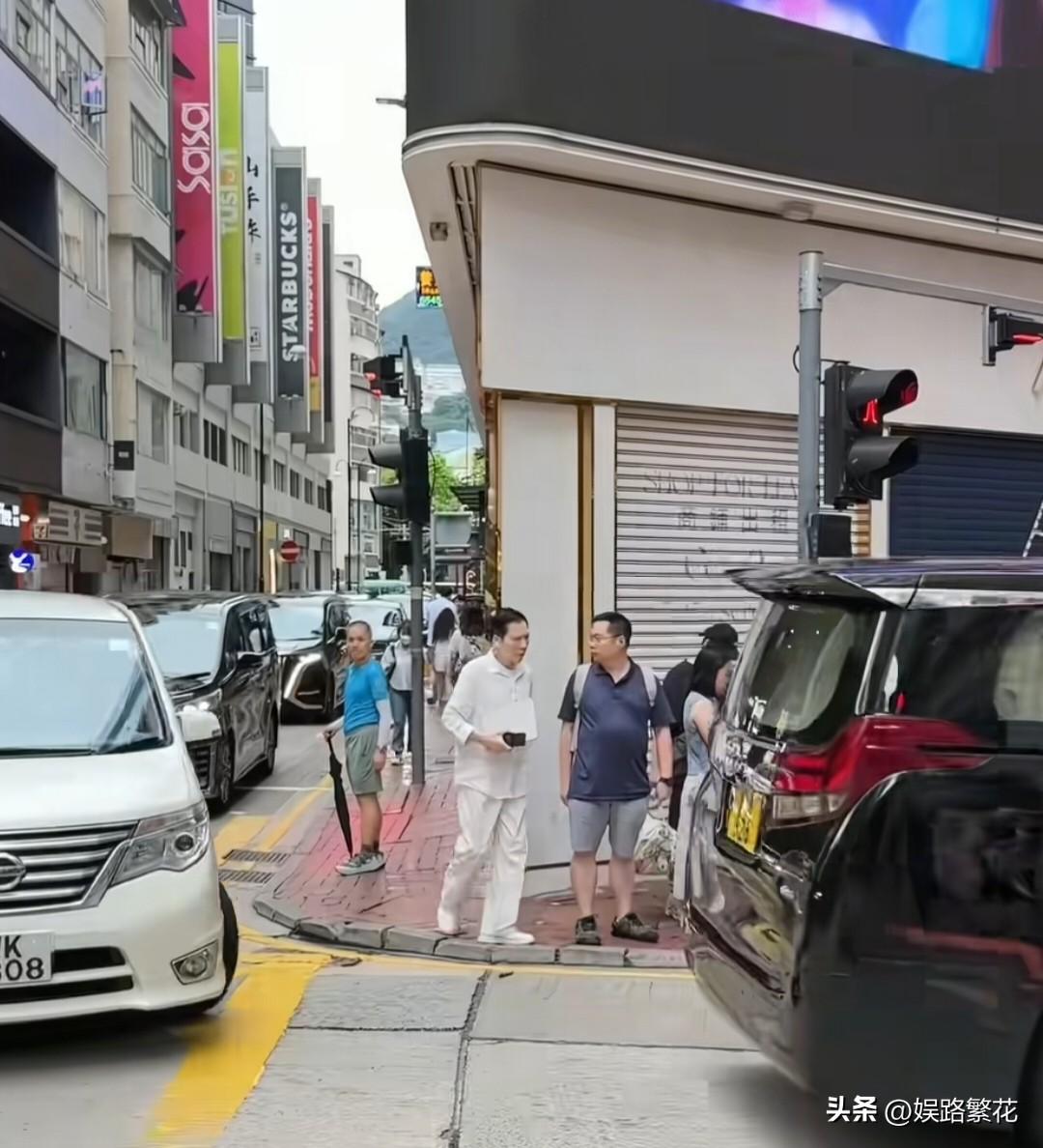 6月24日，有网友在香港铜锣湾街头偶遇向华强。一身纯白休闲装白衬衫配同色系长裤，