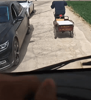 也皆有可能大爷是为了避地上的坑，怕车子上的豆腐给颠碎了，才往平整的地方走，而没有