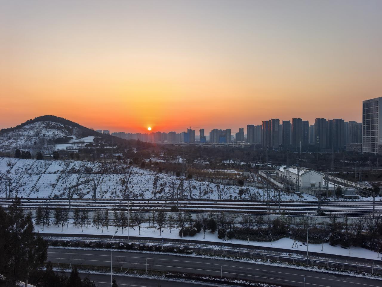 夕阳西下，
美景如画。
晚霞俯照雪后凤凰山，
橘红色的夕阳温馨的告别大地，
最后