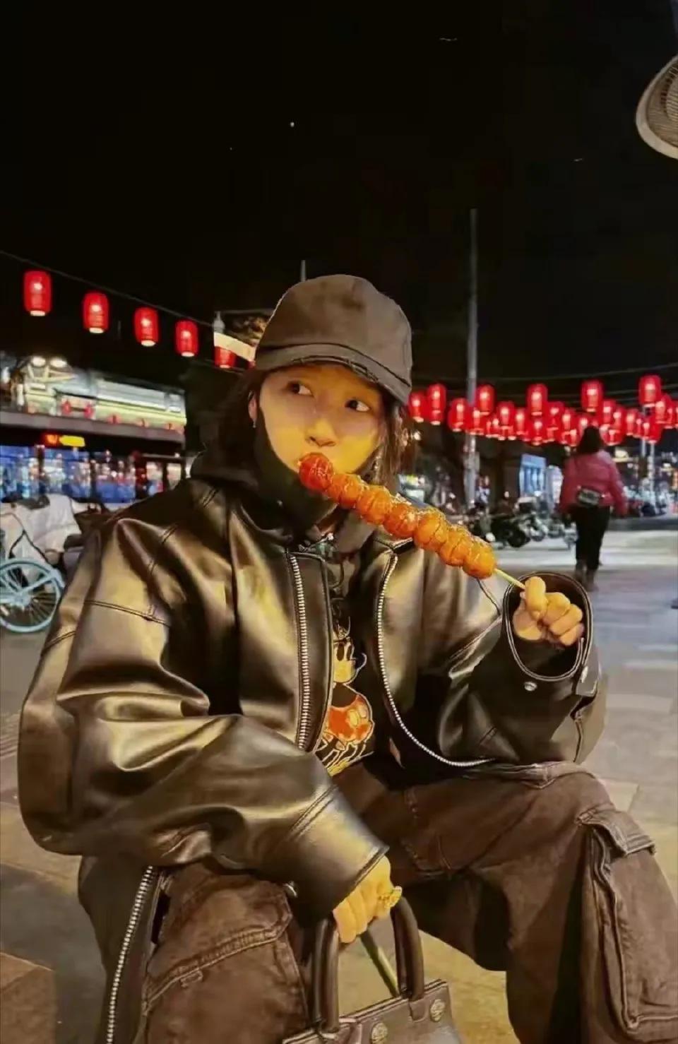 关晓彤穿着皮大衣，坐在路边啃冰糖葫芦，不愧是北京娃子，感觉她的身上有一种北京孩子