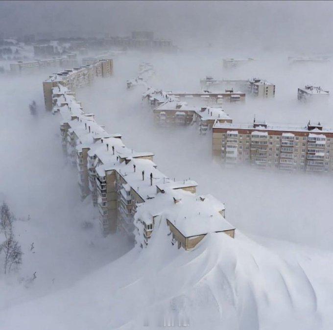 俄罗斯卡马чат卡地区罕见的壮观雪景：大片积雪将整座高层建筑完全掩埋。画面令人震