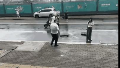 男子费力把井盖复位，这一善举避免了风险的发生。善无大小，都值得赞美。