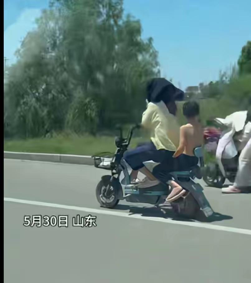 绝对亲生的！
​5月30日，山东，妈妈骑着电动车带着儿子，因为太阳大，妈妈怕晒，