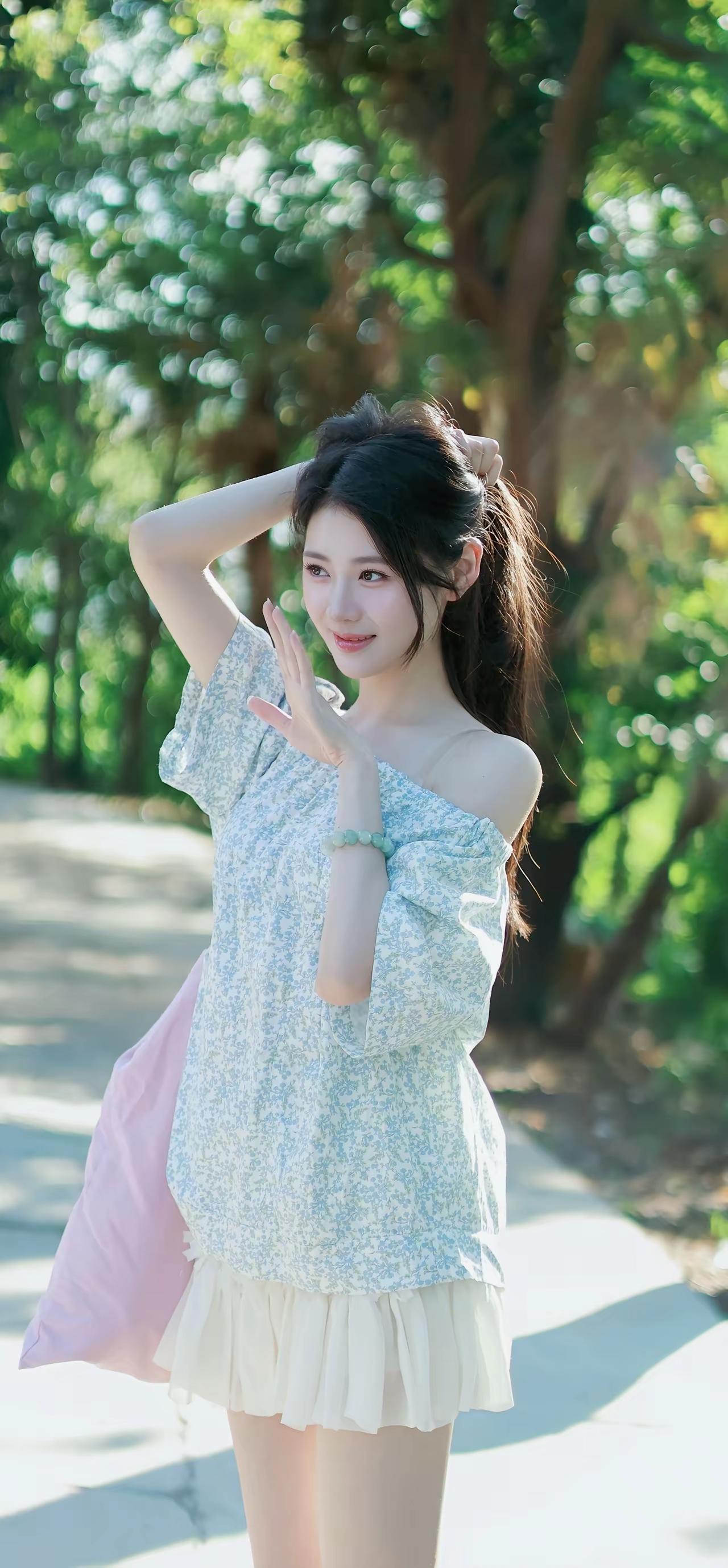 一个女孩在阳光明媚的公园里摆姿势。美女姿势照 温柔风少女拍照 公园拍照动作