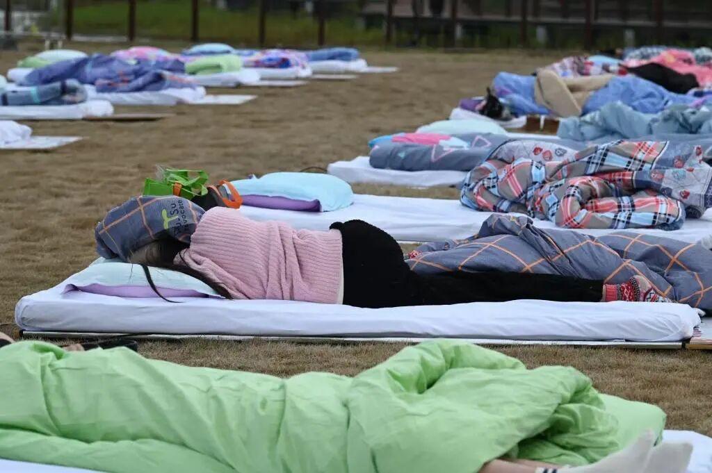 上海举行睡眠大赛现场曝光！
现场很多人躺平在草坪上，大赛为选手设置了万元以上的奖