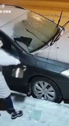 咱谁都不服，就服这大姐！下完雪又上冻，她的车挡风玻璃结了冰，不大好刮，有点着急。