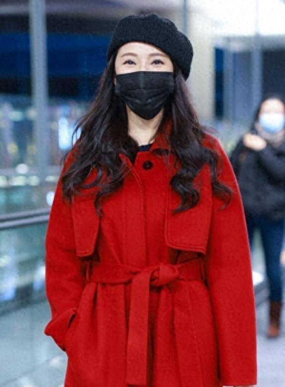 57岁伊能静不服老，机场穿红大衣+长筒靴+贝雷帽，越老越时髦