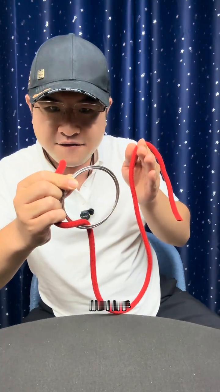 铁环穿越麻绳。
大家好，绳子的中间有一个铁环，它没有任何的问题。接下来把铁环从绳
