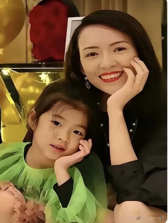 这张照片里，章子怡温柔的用手托着脸，一脸幸福的笑容。

醒醒也学着妈妈的样子，歪