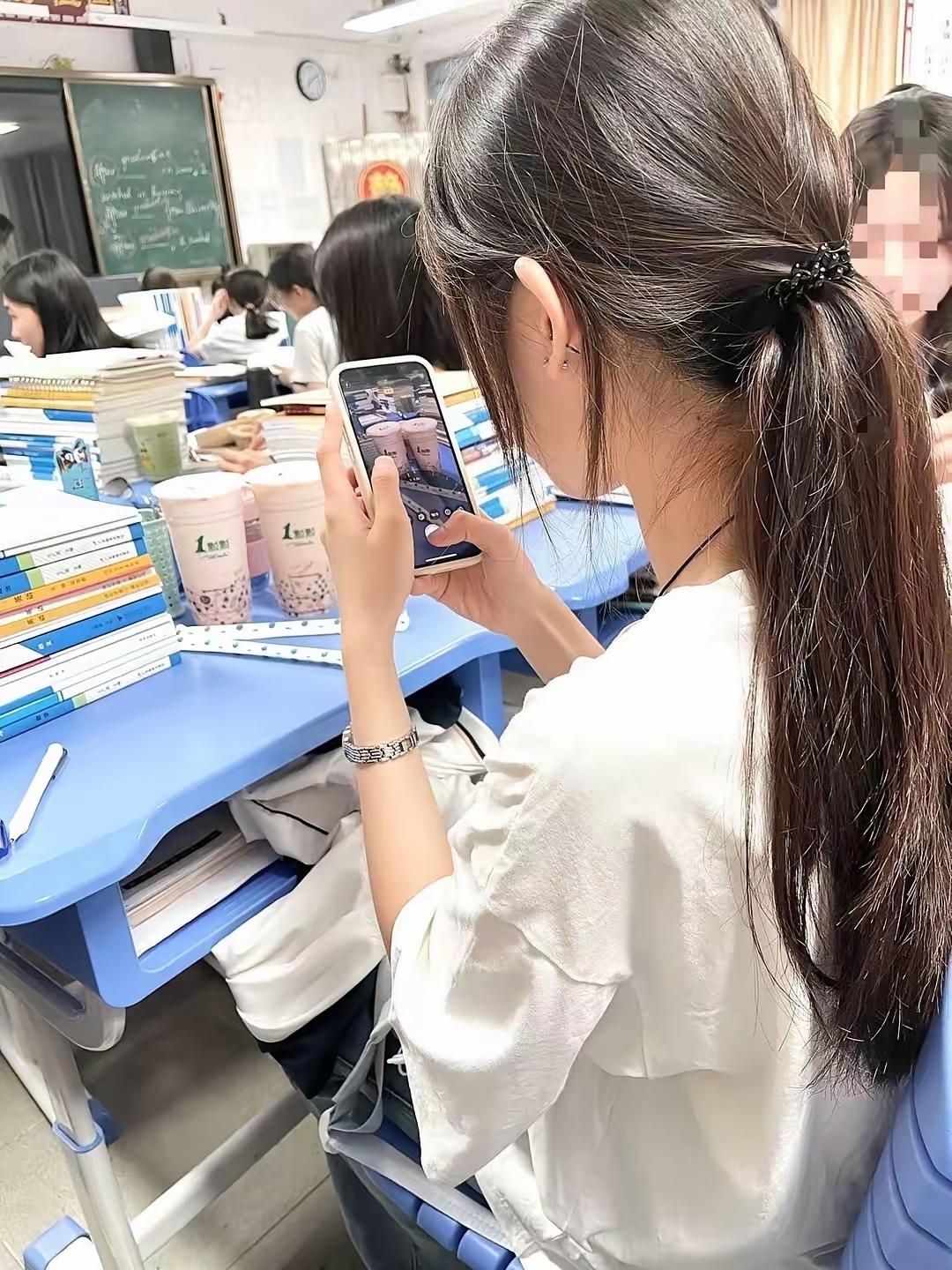 学生在教室里用手机拍奶茶。甜美教室自拍  校园风景自拍 校园萌趣自拍 自拍奶茶 