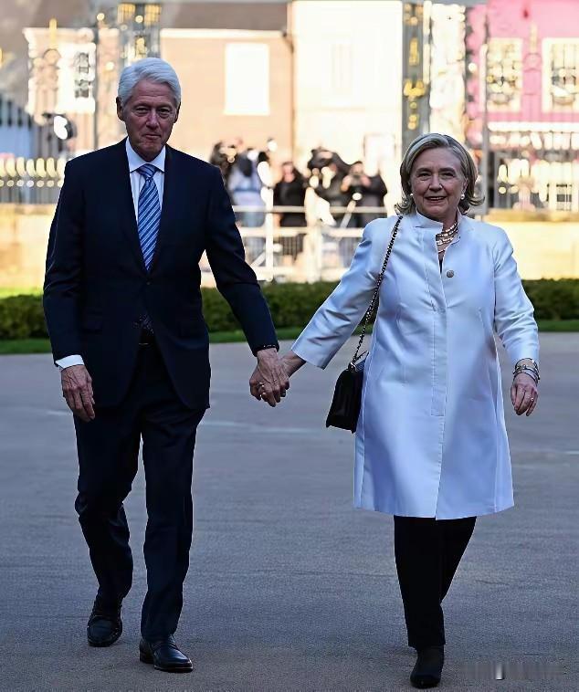 2025年5月，克林顿与希拉里街头合影。镜头下，78岁的克林顿身着深色西装，头发