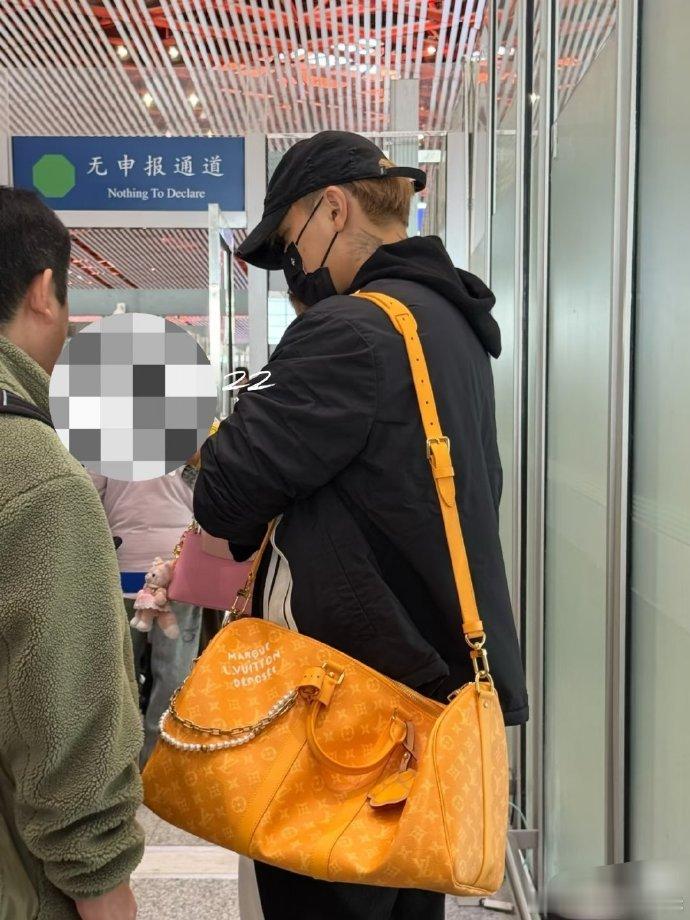 北京机场的安检区域，黄子韬配合检查流程，徐艺洋陪伴在侧，两人全程保持近距离，互动