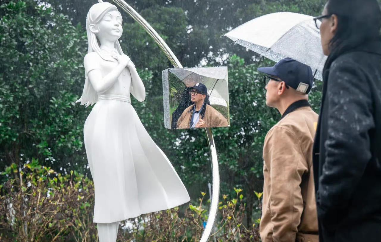 别再传她“走了”。
他没给她立冰冷的雕像，他把她的名字，刻进了自己的肉里。
一个