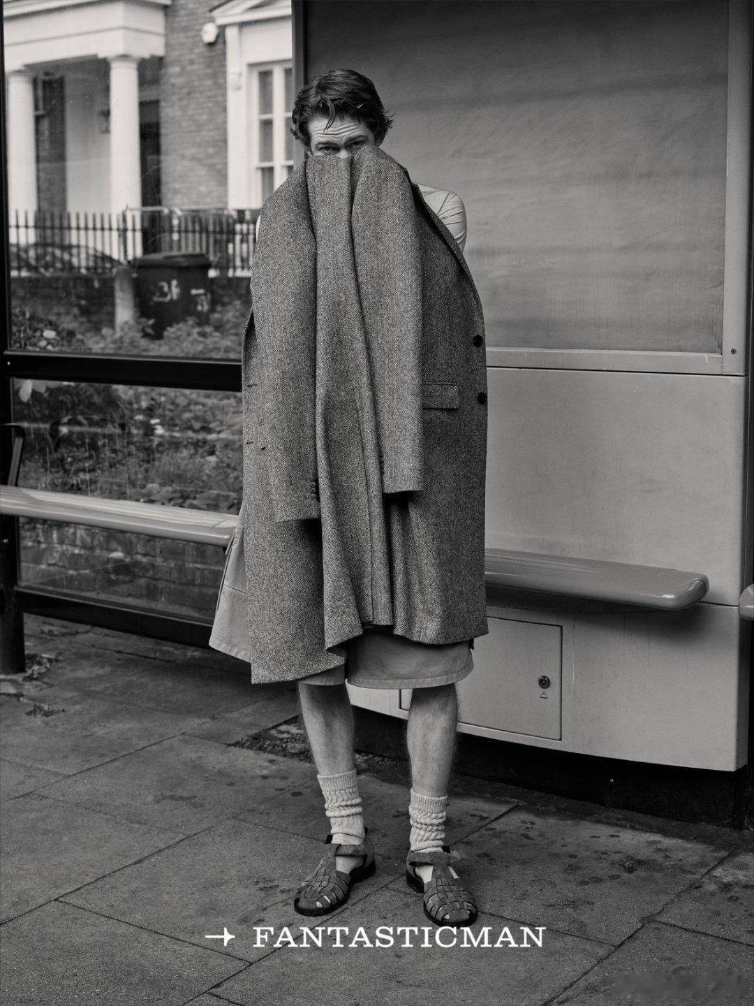 羊毛大衣裹着石膏像静坐长椅，古典与街头在风里碰杯，时间也为这荒诞驻足。粉毛衣配领