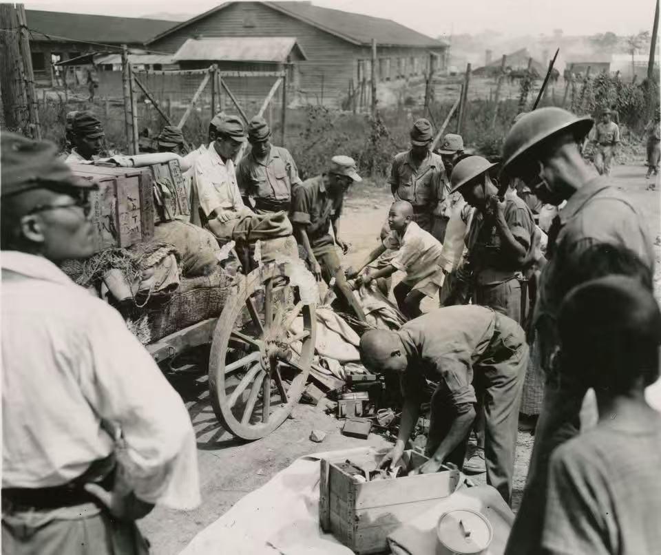 1945年抗战胜利后，国军士兵正在搜查缴械日寇携带物品！可见战士们混搭德式军服与