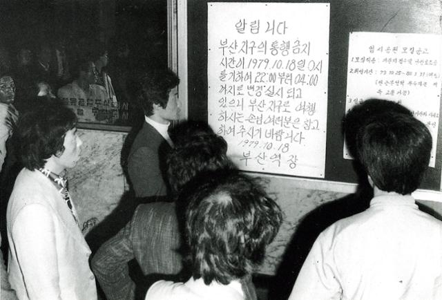 1979年10月，釜马事件爆发，韩国釜山，查看宵禁命令的市民。釜马事件，是朴正熙