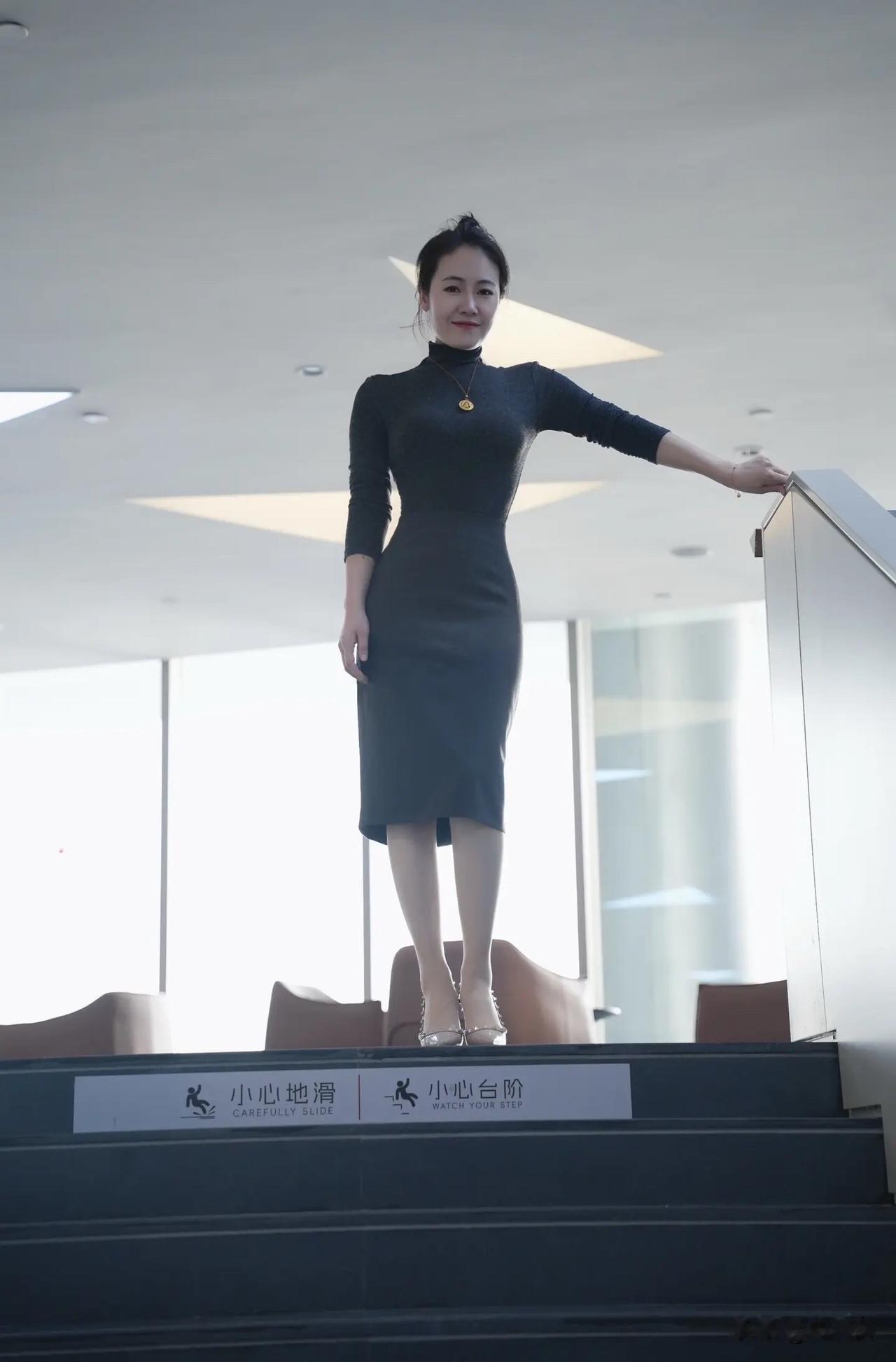 一个漂亮姐姐在扶梯上微笑。
