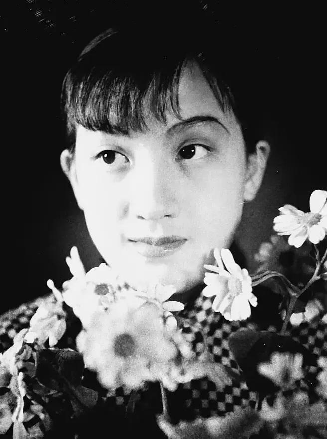 1937年上海，吴印咸镜头下的“金嗓子”周璇。鲜花簇拥，眉眼清澈，属于旧上海的光