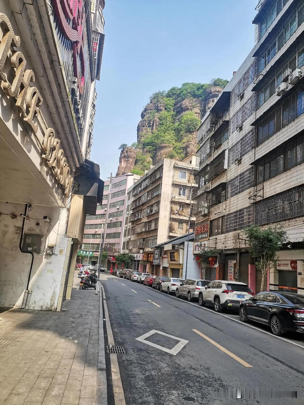 金鸡岭山脚下的狭窄街道，照片背景那拔地而起巍峨竖立的金鸡岭。

金鸡岭牌坊，火车