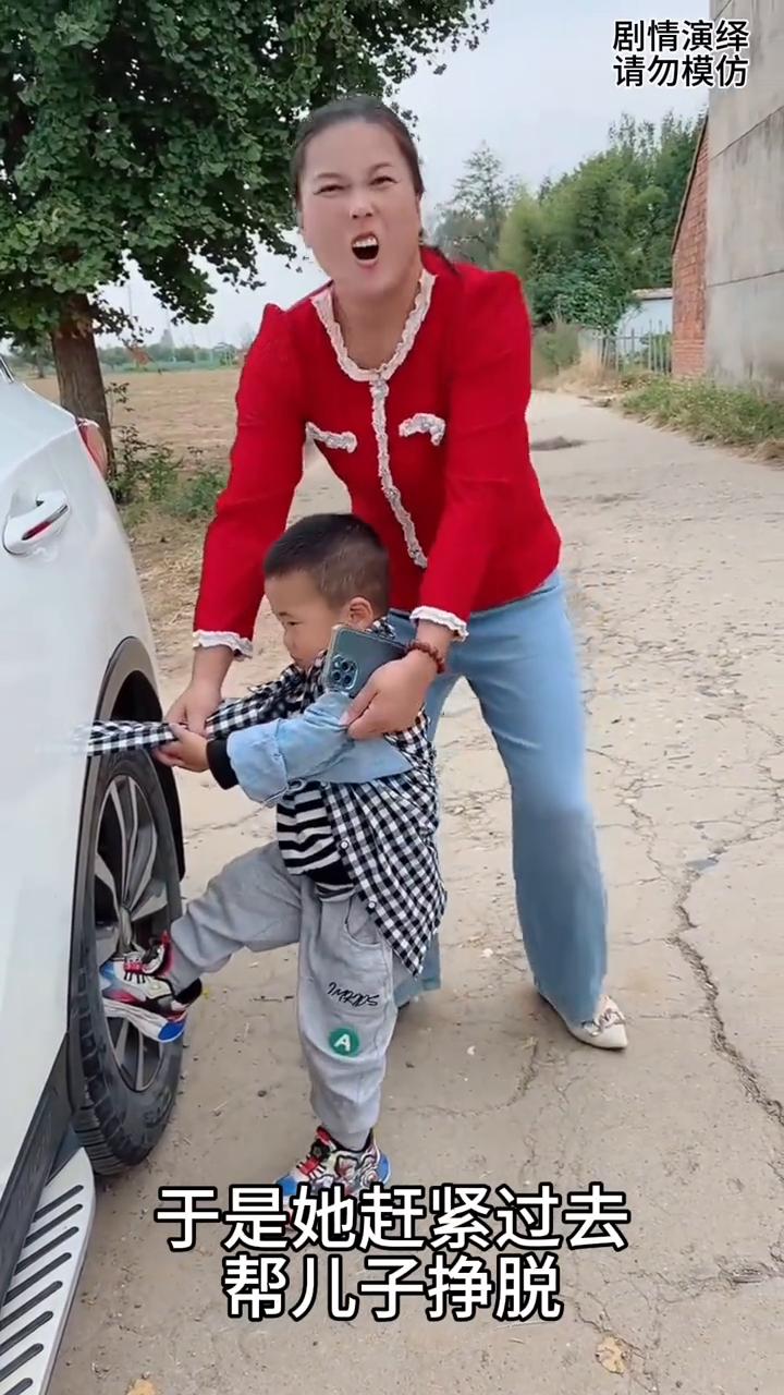 妈妈帮儿子拽夹在车里的衣服，下一秒她的做法太搞笑了。
男孩衣服夹在车门里了，这时