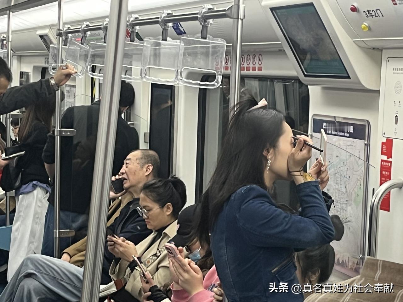 对镜贴花黄。西安地铁上，一位女士拿着化妆镜旁若无人的补妆，画面撷取温馨浪漫的场景