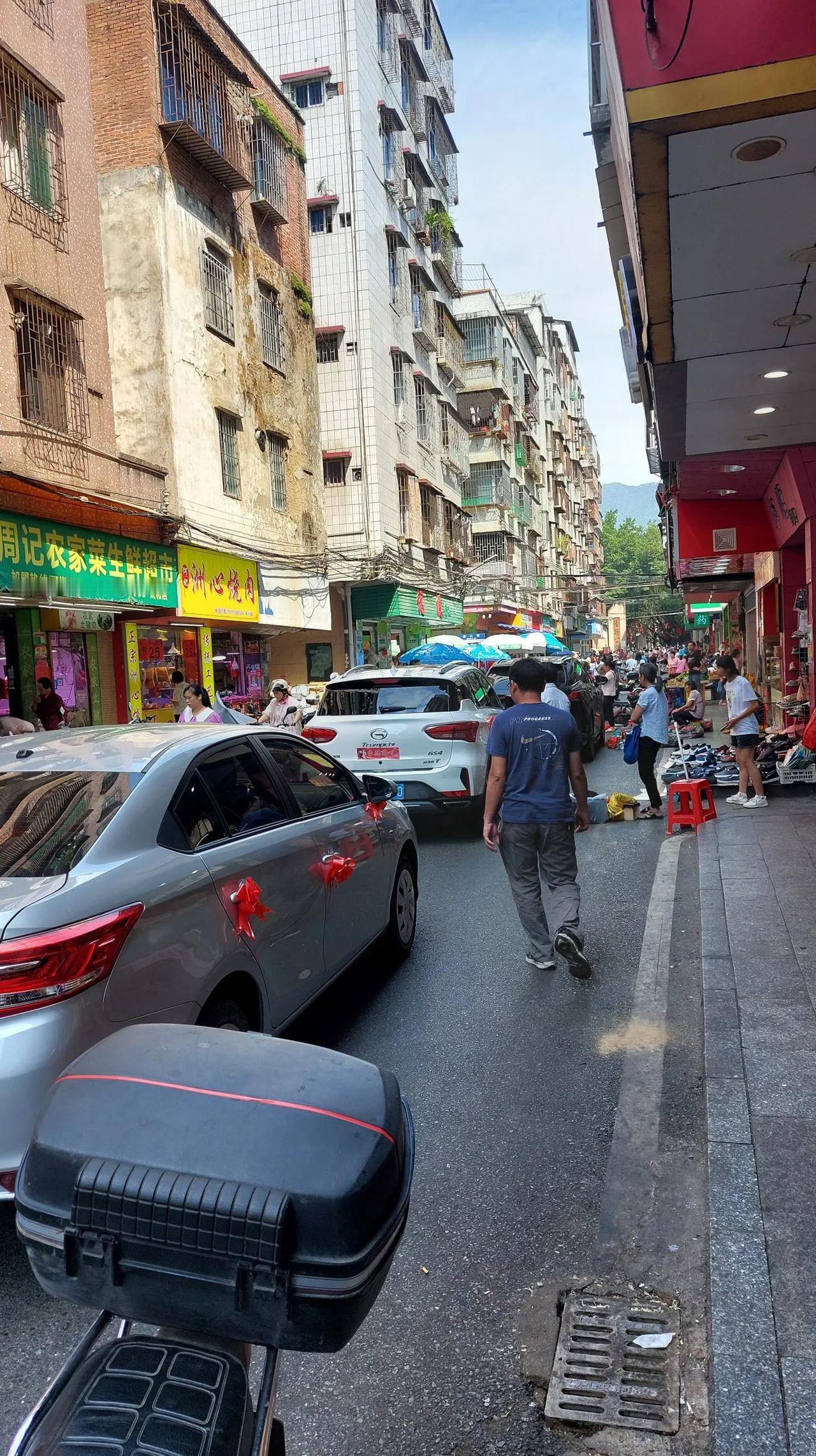 婚车队？在清新公园后门停下来的婚车队伍，似乎被街上拥堵的人群堵到无法前行，这条窄