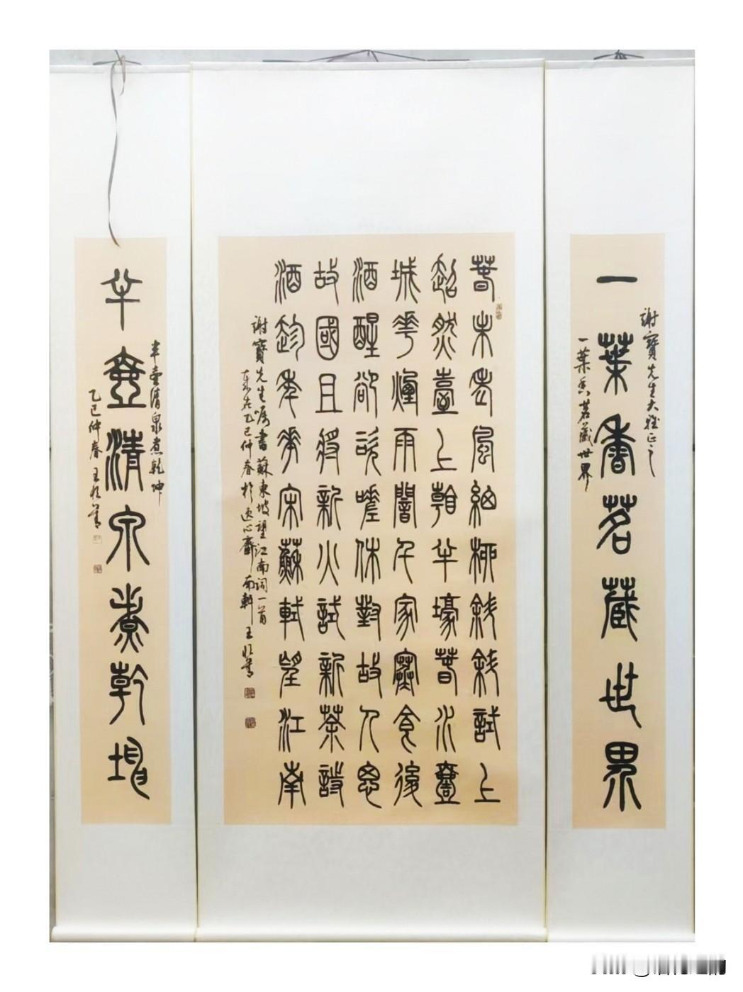一幅篆书中堂对联，古雅端庄，笔墨沉静。
中堂书写苏轼《望江南》，搭配两侧楹联：一