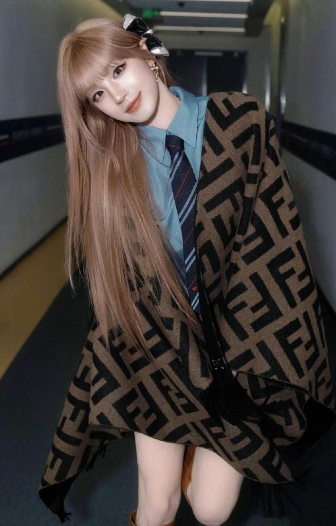 内搭蓝色衬衫与条纹领带，搭配棕色长靴与蝴蝶结发饰。浅色头发好亮眼，英伦时尚感十足