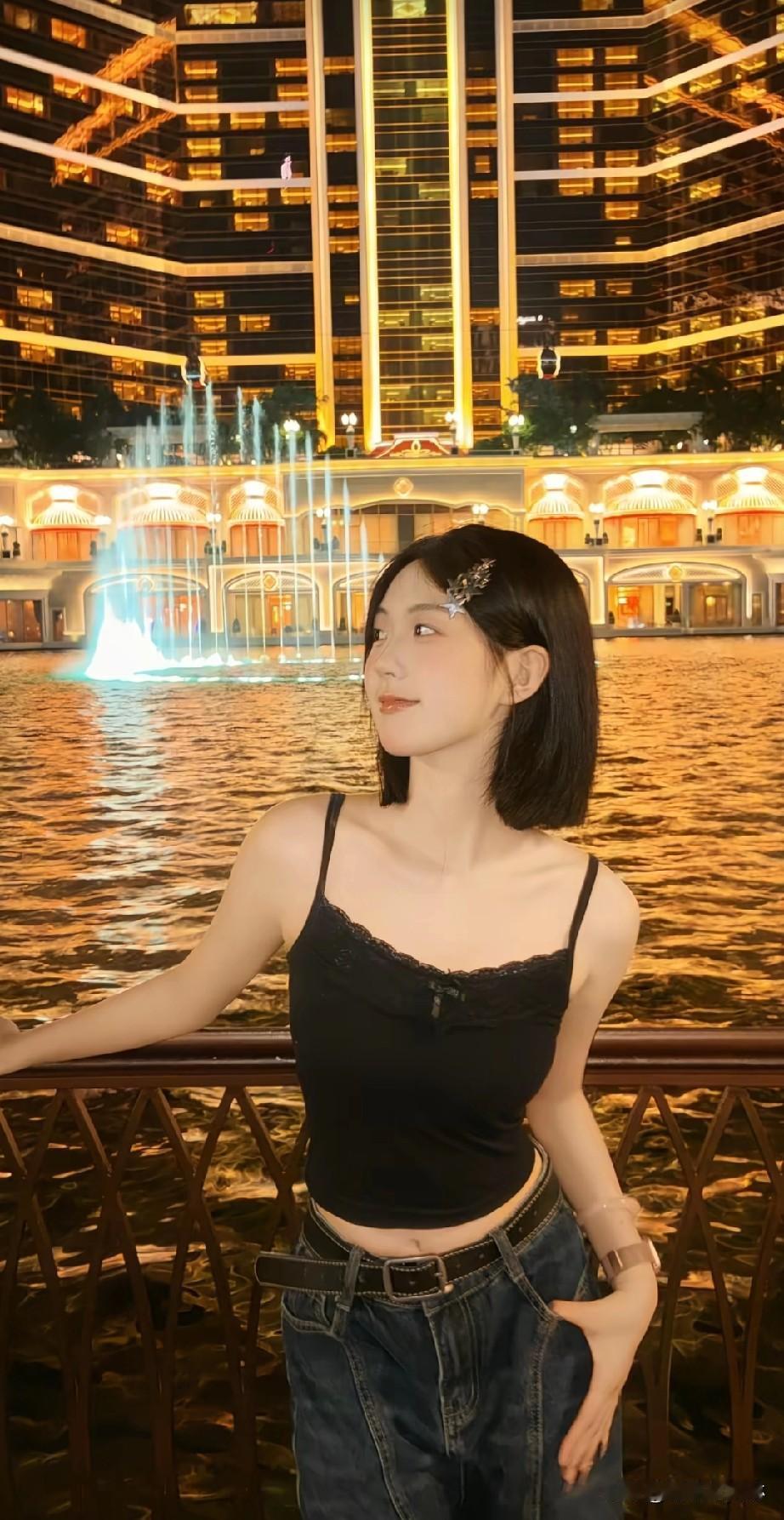 夜晚的璀璨灯光下，少女与水边相映成趣，尽显青春活力！