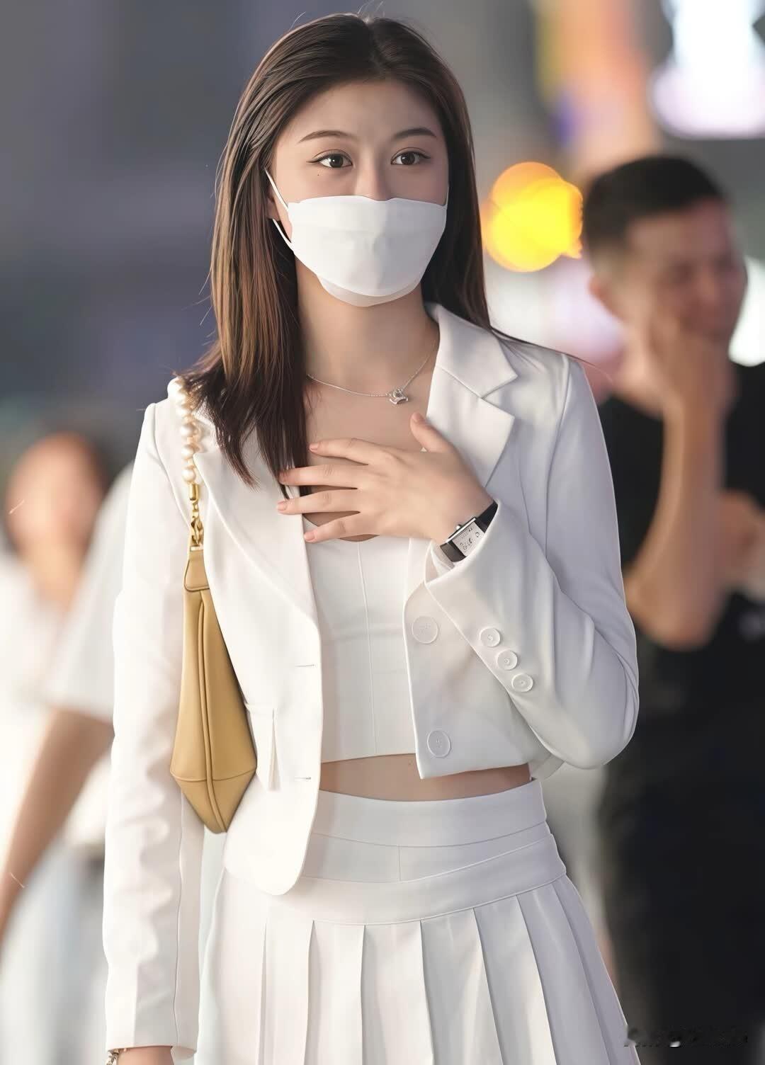 穿着白色套装的女士在街上走着。
