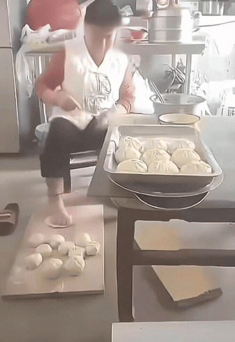 大妈做包子的姿势够狂野，手不够，脚来凑；这充满“力量感”的包子，咬一口，绝对元气