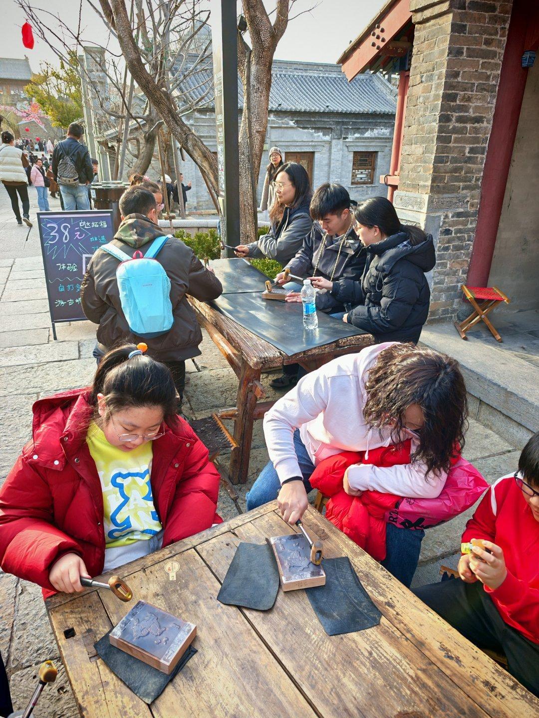 景区里，一堆人敲敲打打，还以为是啥呢。自己花钱，自己动手做一个小画框，价格也不便