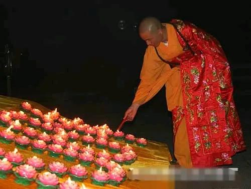 印乐法师点燃莲花形状蜡烛，画面真寺庙，让人看了心境平静祥和。印乐法师写毛笔字，大