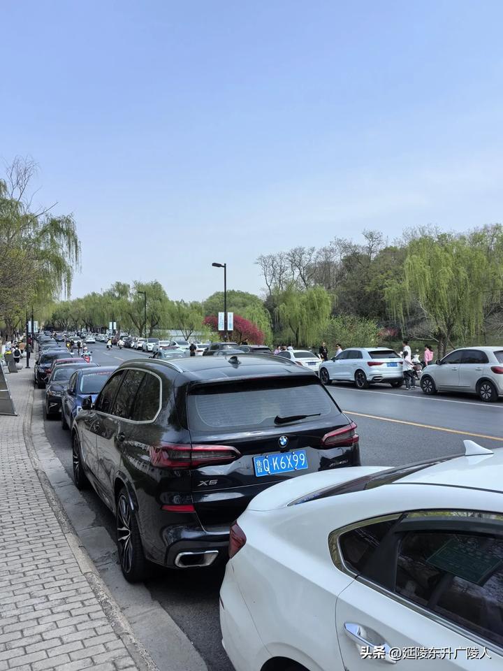 扬州蜀岗瘦西湖周围的道路两边，停满了外地牌照的车辆。还有警察帮忙管理，扬州对游客