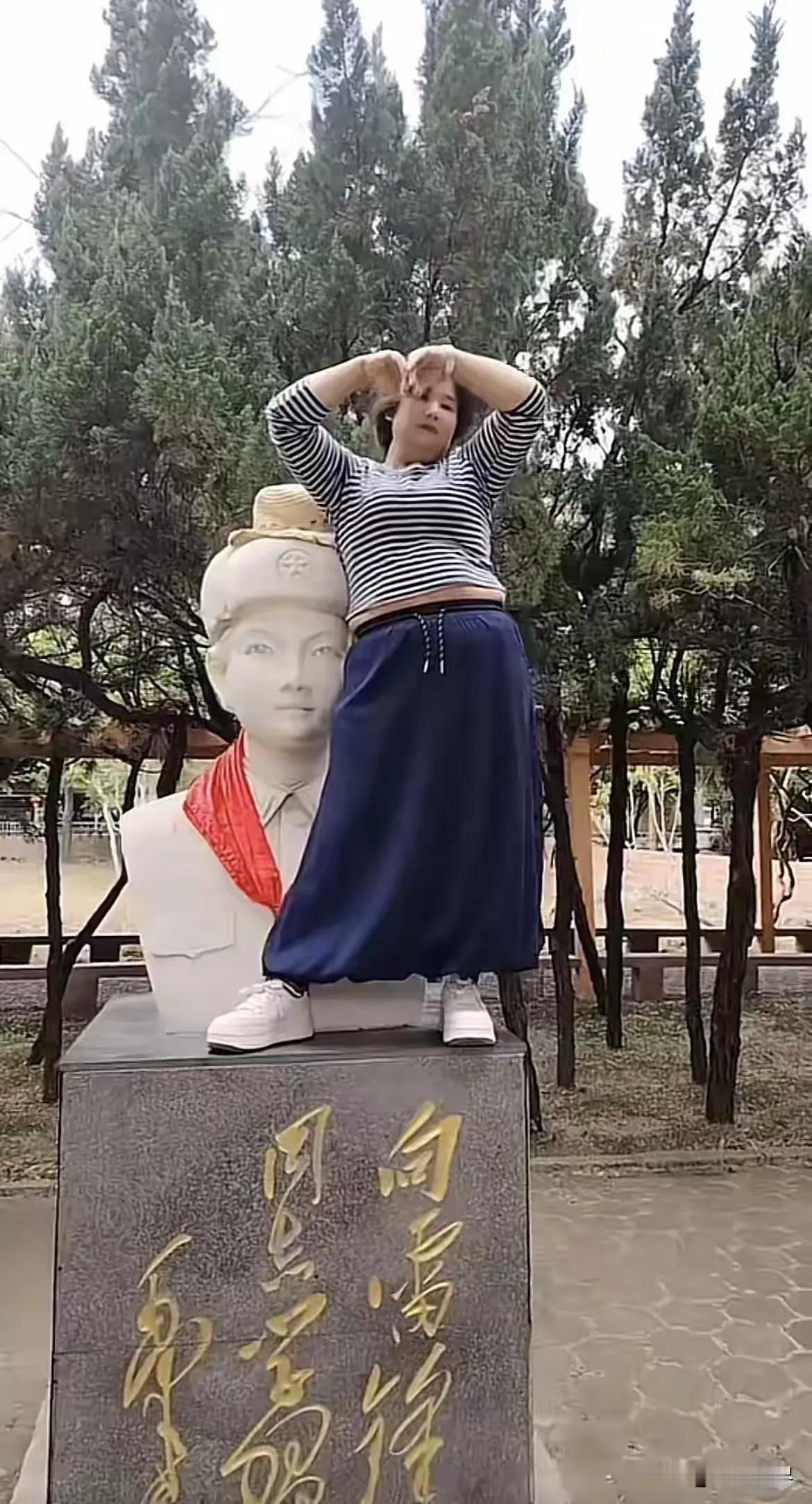 这种人该怎么处理？她竟然爬到英雄的坐像上拍照！简直是大逆不道！

有网友气愤地说
