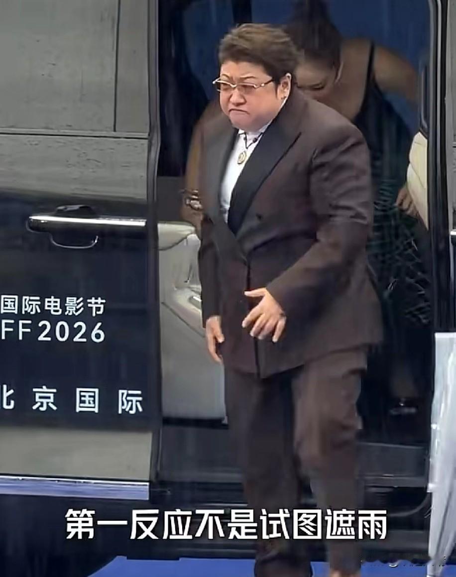 韩红和高叶一同出席北京国际电影节，现场下着瓢泼大雨，韩红下车后紧皱眉头，立刻转身