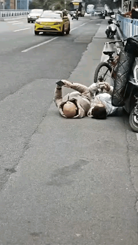这两个人躺在地上都打手机，把人看的莫名其妙，大冷的天，躺在地上多凉啊，看他们的意