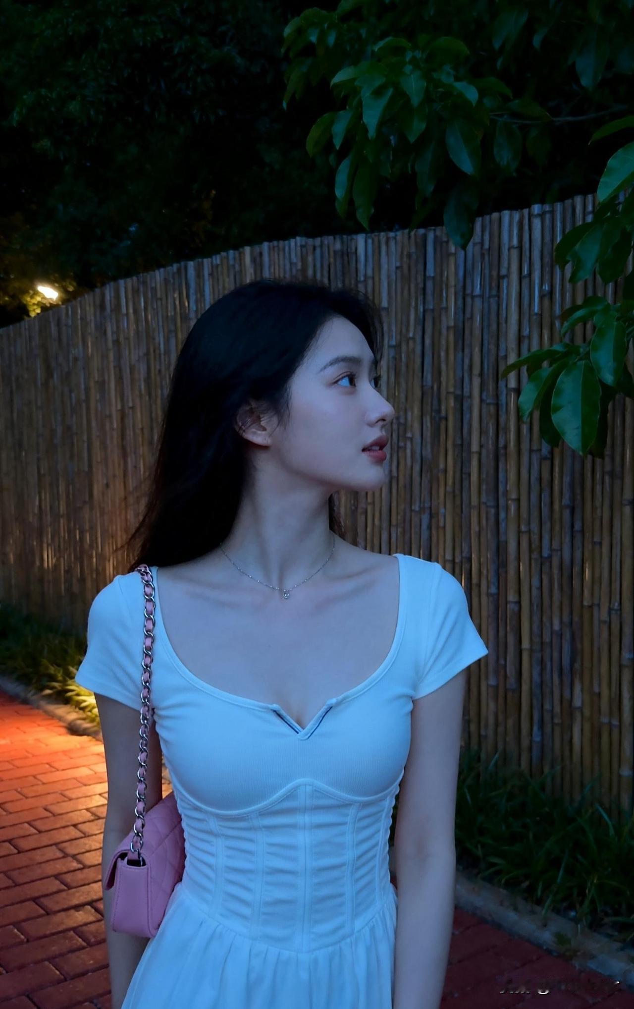 夜晚的竹林小道，少女轻盈漫步，粉色包包点缀，浪漫氛围满满。