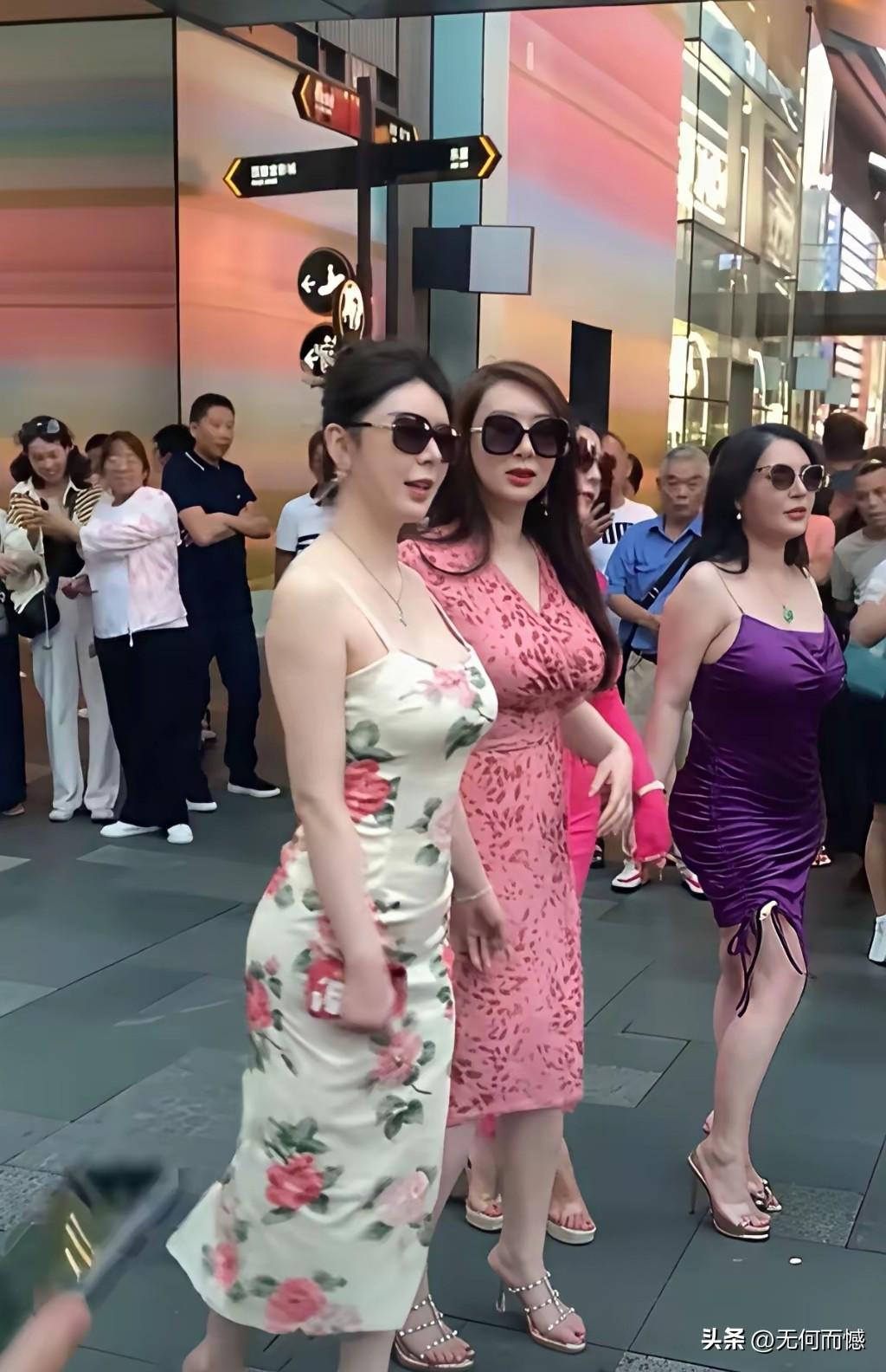 这几个女子，穿着打扮非常的时尚，形成了一道亮丽的风景线，吸引了很多路人观看，看着