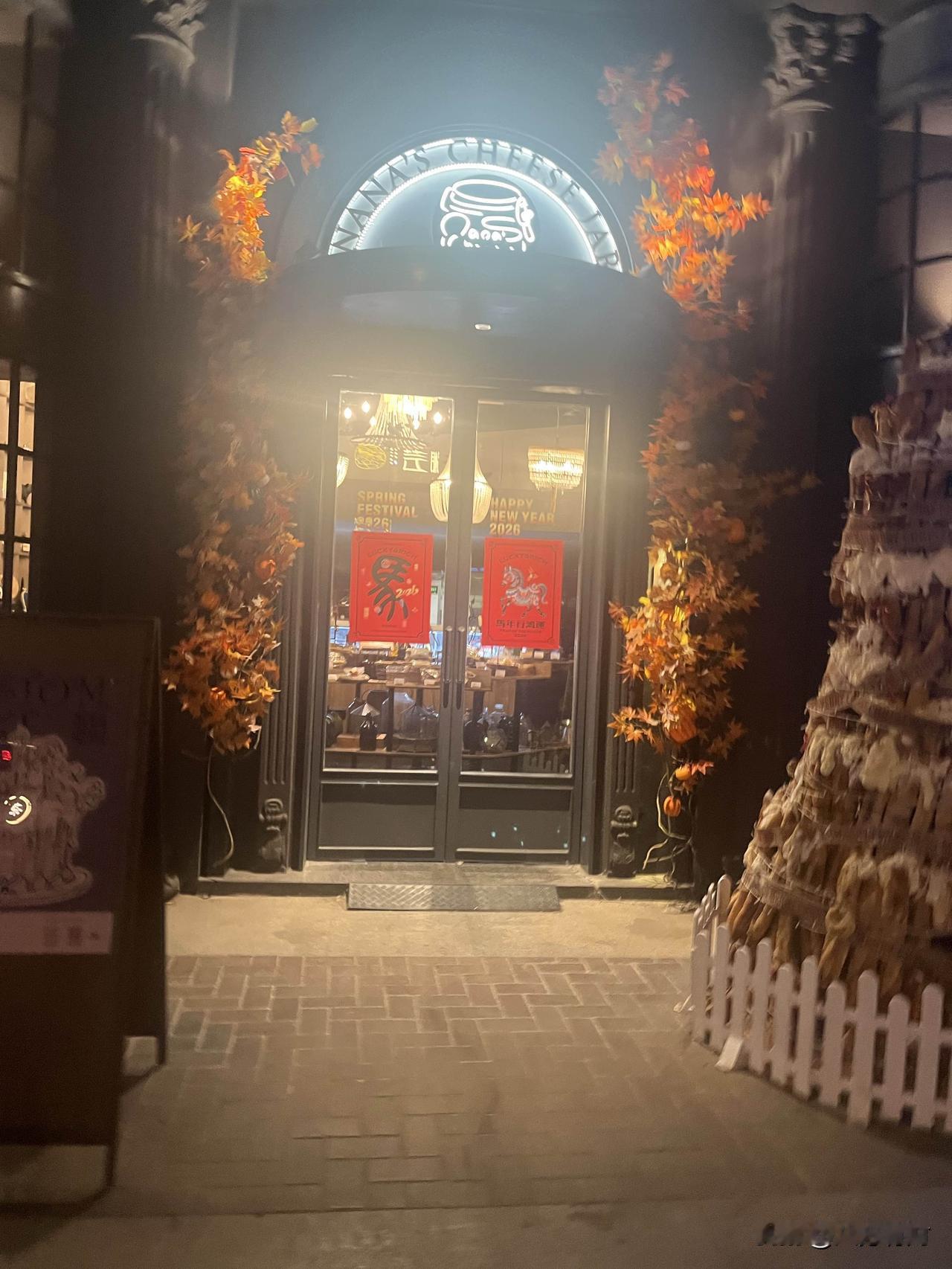 这家装点着圣诞彩灯、圣诞树与可爱玩偶的实体店，主打蛋糕相关产品，从门店招牌上的“