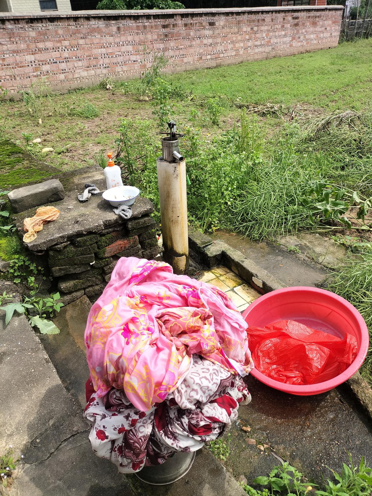 这水桶上面的被套是昨天我从租房带回来老家洗的，家里的井水不要钱，而且今天出太阳了