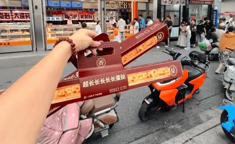 60厘米的超长蛋挞最近在多地烘焙店上架，部分门店出现排队；据新华社报道，一家销售